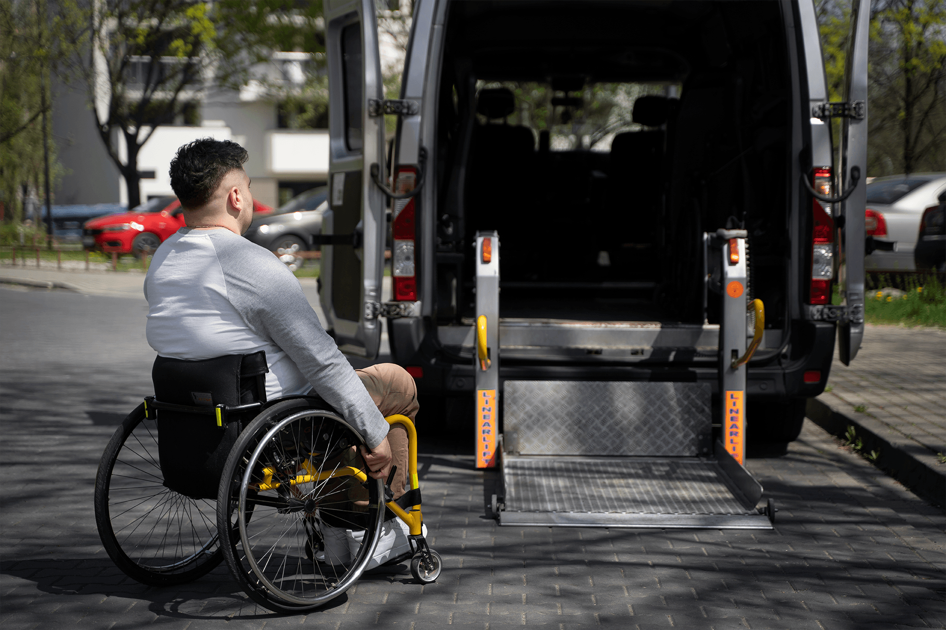 Passenger in a wheelchair boarding a transport van via the rear ramp